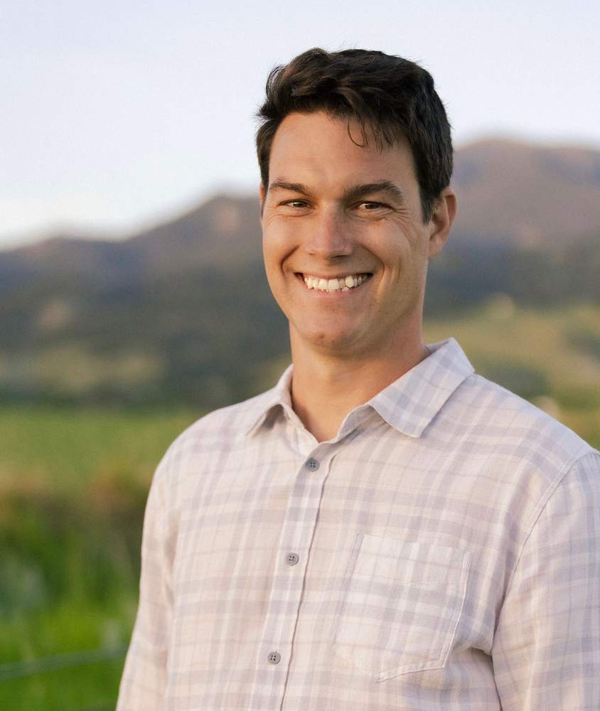 Zach Dobrowski, owner of Dobrowski Built, outdoors with Montana mountains in the background